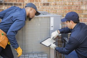 two-technicians-working-on-outdoor-ac-unit
